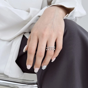 Detailed close-up of S925 sterling silver wavy ring with small spherical tassel charms