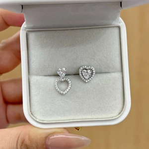 Detail showing asymmetrical S925 silver heart stud earrings with cubic zirconia inlay