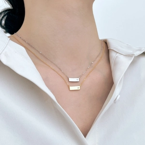 Elegante collana a barra in argento S925 con stella incisa indossata su camicia bianca