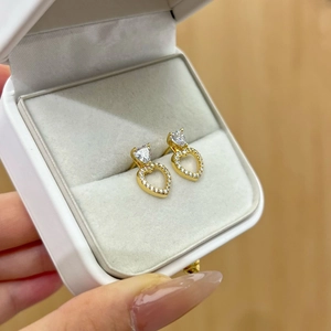 Detailed view of S925 sterling silver hollow heart earrings with sparkling cubic zirconia