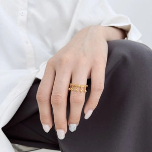 Minimalist gold S925 silver ring with five dangling bead charms on a female hand