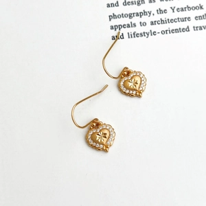 Exquisite gold heart earrings with brushed finish and sparkling starburst center