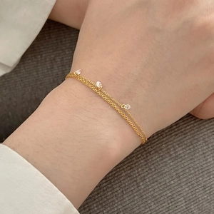 Bracelet élégant double chaîne dorée orné de trois pendentifs ronds en zircone claire