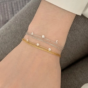 Gros plan de bracelets S925 en argent à plusieurs rangs avec charms en zircon au poignet