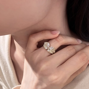Détail d'une bague papillon dorée avec zircons marquises et ronds sur un doigt de femme
