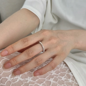 Close-up of S925 silver ring featuring elegant row of small white pearls on a hand