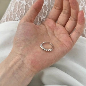 Close-up of minimalist S925 sterling silver ring with nine white pearls on a hand