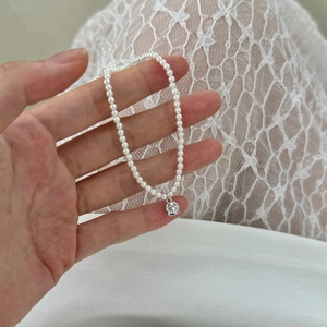 Close-up of S925 silver necklace with small white pearls and zircon square pendant