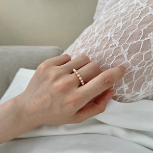 Detail of 925 sterling silver ring featuring a row of six elegant white pearls on gold band