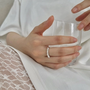 Detailed view of S925 sterling silver ring featuring an elegant row of white pearls on hand