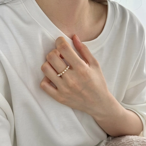 Detail of elegant S925 silver pearl ring with white pearls on a gold band for women