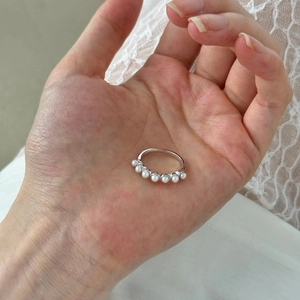 Close-up of S925 sterling silver ring featuring seven elegant white pearls on lace
