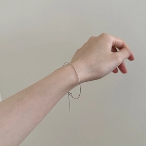 Close-up of minimalist S925 sterling silver adjustable bracelet worn on a female wrist