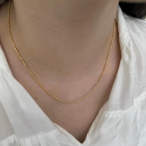 Gros plan d'un collier ras du cou minimaliste en argent S925 doré avec perles rondes