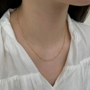 Détail d'un collier ras du cou minimaliste en argent S925 doré avec perles fines