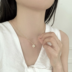 Close-up of golden S925 sterling silver four-leaf clover heart necklace on female neck