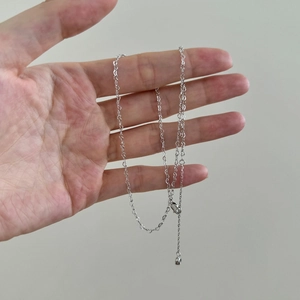 Detailed view of S925 silver wave chain with lobster clasp and round ball charm