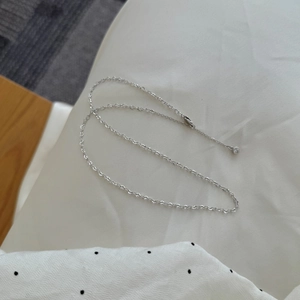 Close-up of S925 sterling silver chain with lobster clasp and a tiny zircon pendant