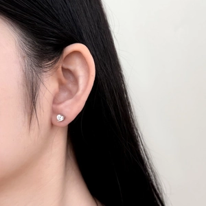 Detailed view of S925 silver heart-shaped earring with clear cubic zirconia on ear
