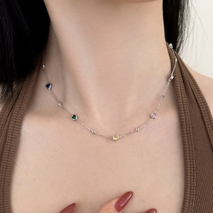 Detail of S925 silver necklace with multi-color heart zircons worn by a model