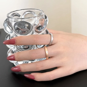 Close-up of minimalist rose gold and silver rings with zircons on model's hand