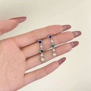 Detailed view of sterling silver drop earrings with rainbow heart-shaped zirconia stones
