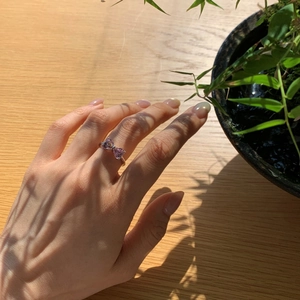 Dettaglio anello in argento S925 con pietre a cuore rosa a forma di fiocco sul dito