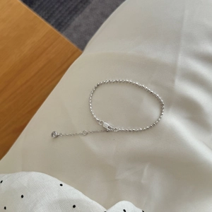 Detalle de pulsera de cuentas en plata S925 con cierre de mosquetón y colgante de circón