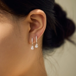 Close-up of S925 silver teardrop earrings with pavé crystals shown on the ear