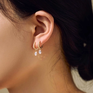 Close-up of gold S925 sterling silver earrings with pear-cut cubic zirconia droplets
