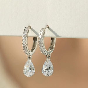 Macro shot of S925 sterling silver hoop earrings with pear-cut cubic zirconia drops