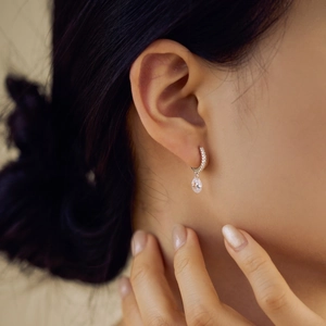 Close-up of elegant S925 sterling silver hoop earrings with oval zircon drops on model