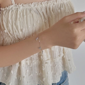 Gros plan d'un bracelet en argent S925 avec breloques colibris et zircons étincelants