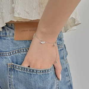 Détail du bracelet papillon en argent S925 avec zircons scintillants au poignet féminin
