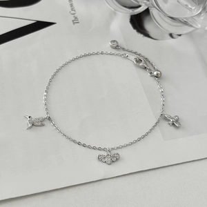 Détail d'un bracelet en argent S925 avec breloques colibri et abeille serties de zircons