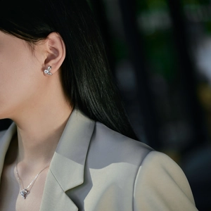 Close-up of bow knot jewelry set with silver finish and white zircon on an Asian model