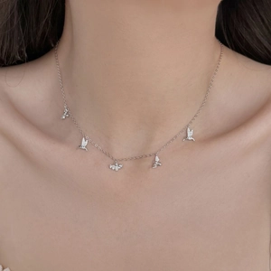 Gros plan d'un collier en argent S925 avec pendentifs colibri et abeille sur le cou