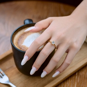 Classic gold s925 silver ring with a sparkling six-prong round zircon worn by a model