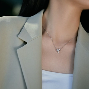 Elegant sterling silver key necklace with pavé zircon worn by a model in office attire