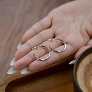 Créoles minimalistes en argent S925 avec pavé de zircone sur un plateau en bois élégant