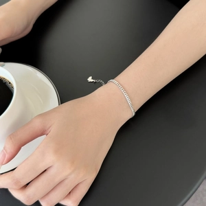 Detail of S925 sterling silver chain bracelet with butterfly charm on a model's wrist