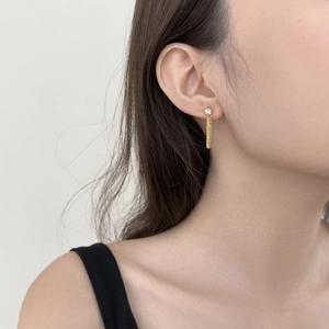 Detail of S925 silver fringe earring with gold tassel and sparkling zircon on a model