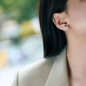 Close-up of S925 sterling silver bow earrings with micro-pave zircon on model's ear