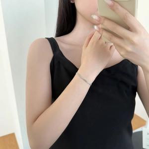 Minimalist silver chain bracelet worn by a model in a casual lifestyle mirror selfie