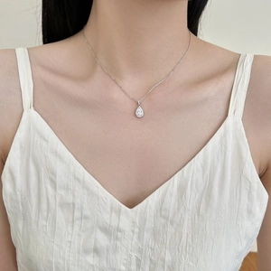 Dettaglio della collana in argento S925 con ciondolo a goccia su donna con top bianco