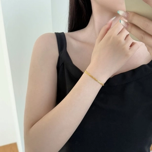 Close-up of minimalist golden woven S925 silver bracelet worn on a woman wrist