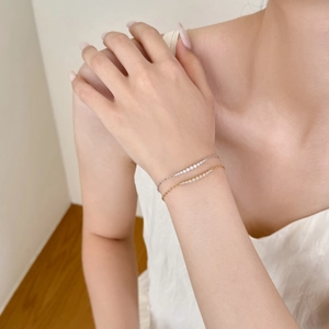 Dettaglio di bracciali minimalisti in argento S925 con zirconi pavé su un polso