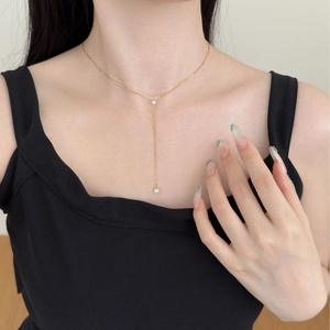 Elegant 18K gold Y-shaped necklace with dual zircon pendants worn by a female model