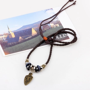 Vintage bronze shield pendant with dark brown braided rope and decorative beads