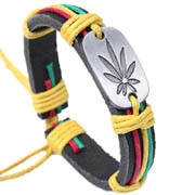 Dettaglio del bracciale in pelle intrecciata con fili Rasta e piastra con foglia